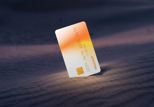 Vertical credit card mockup with orange gradient design standing in desert sand dunes at sunset with soft shadows