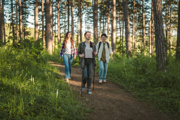Fototapeta premium Female friends hiking forest trail enjoying nature adventure