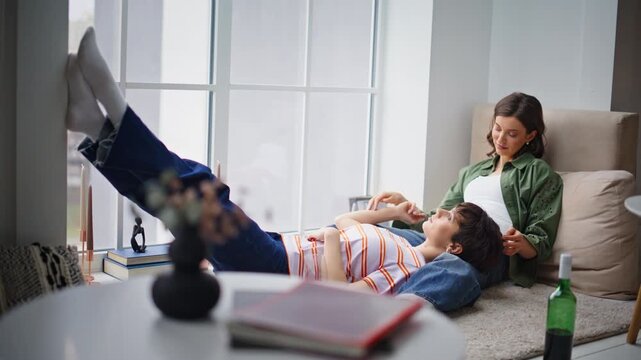 Affectionate bisexual couple relaxing in living room. Lesbian couple talking