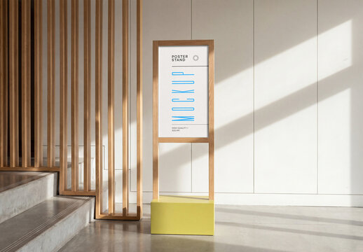Vertical wooden poster stand mockup with yellow base in a modern interior next to concrete stairs and white wall with geometric shadows