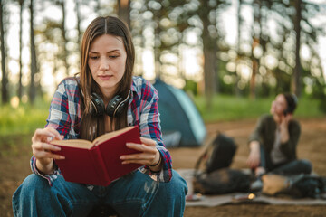 Woman reading book at campsite relaxing in nature © Miljan Živković