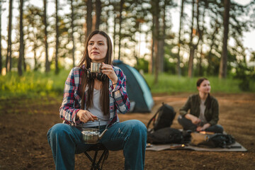 Obraz premium Friends enjoying fresh brewed coffee while camping in forest