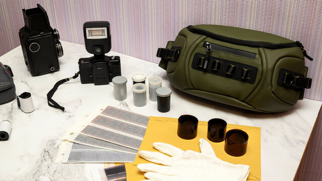 film negatives and white gloves on table with vintage gear