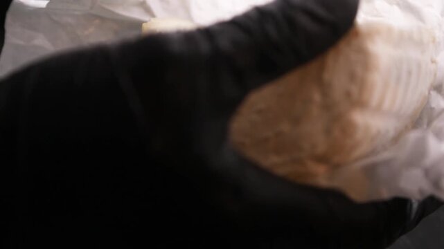 Chef cortando queso de cabra artesanal sobre mostrador negro. Chef profesional rebanando queso de cabra hecho a mano sobre una superficie negra. Productos l&aacute;cteos artesanales, preparaci&oacute;n culinaria 