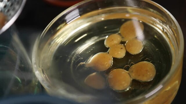 Chef creando esferas de compota de manzana mediante gastronom&iacute;a molecular. Un chef profesional crea esferas de compota de manzana. Gastronom&iacute;a molecular, t&eacute;cnica culinaria de vanguardia.