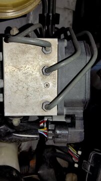 Camera pans slowly over a dusty car ABS modulator block