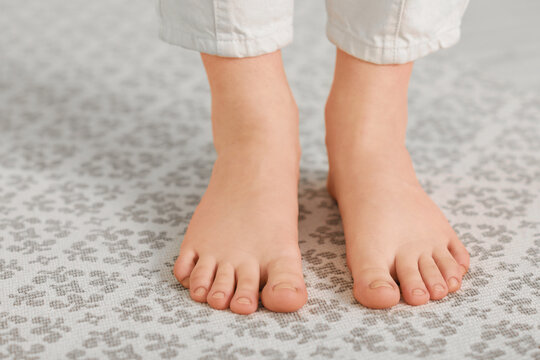 Barefoot woman on rug at home, closeup