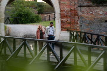 Couple walking on bridge through old castle archway © Zoran Jesic