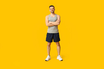 Obraz premium Handsome sporty young man on yellow background. Weight loss concept