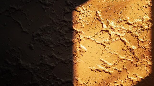 Textured abstract surface with rough, uneven terrain illuminated by a warm golden light on the right side, casting a deep shadow on the left, creating a sense of depth and mystery Keywords
