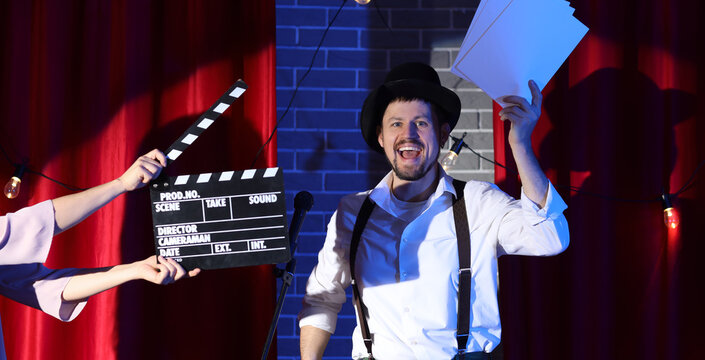 Male actor and female hands with movie clapper acting on stage during audition