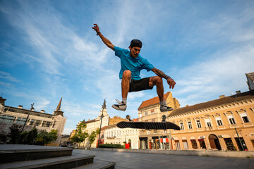 Skateboarder performing kickflip trick in urban city square © Zoran Jesic