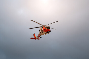 Search and rescue helicopter flying overhead against cloudy sky © cole
