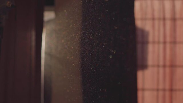 A video of beautifully moving particles in the air in a dark room, appearing when sun's rays penetrate through the cracks of window curtains. Beauty in everyday things, abstract harmony, tranquility