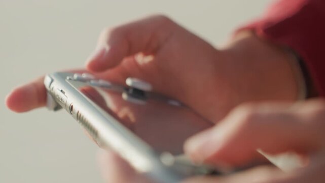 Closeup of controller. Device being pressed with soft lighting. Close shot of thumb pressing controller buttons carefully. Indepth view of fingers operating device under warm lighting and detail