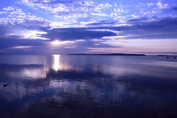 Obraz premium Sun shining through the cloud and reflecting off the Mackinac Straits