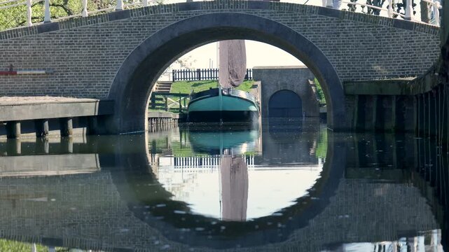 Arched bridge reflecting creating a perfect circle on a canal