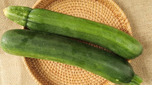 Fresh green zucchini rotating on wicker tray