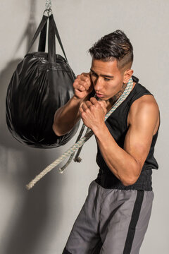 young Hispanic boxer in fighting stance training in gym