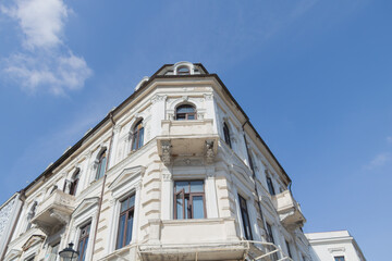 Fototapeta premium Historic white neoclassical building facade under blue sky in Bucharest
