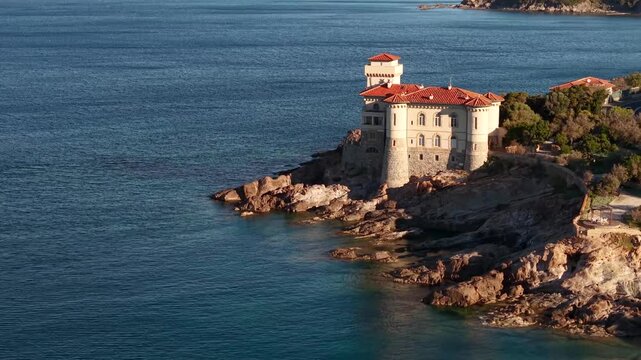 Castello del Boccale Italy 4k drone footage of historic Tuscany castle. Cinematic aerial flight of stone fortress on Livorno rocky coast seascape, beach castle