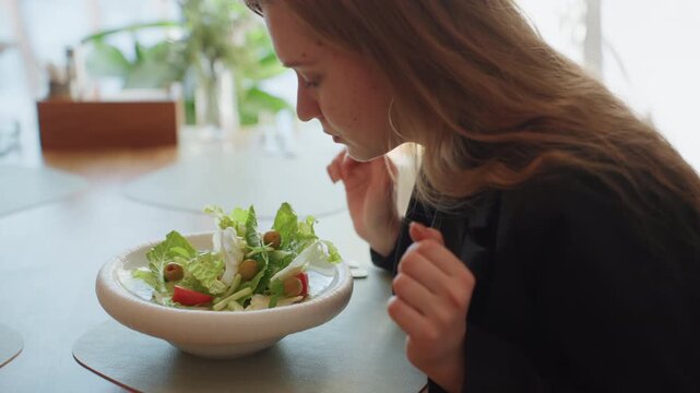 White woman entrepreneur arranging salad bowl on table, closeup of hands mixing greens, casual blazer, bright window light, quick business lunch ritual, textured tabletop and focused motion