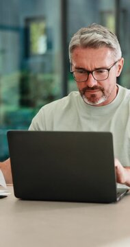 Mature, man and documents with laptop in home for finance, budget planning or tax deduction. Male person, remote work or computer with paperwork or invoices for financial audit or expenses in house