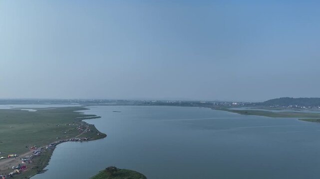 . A top-view drone shot captures various people enjoying a picnic near Deepor Beel, Assam, showcasing a lively scene of fun, food, and nature in a beautiful green setting.4k