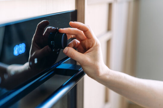 Woman adjust oven temperature for precise food preparation