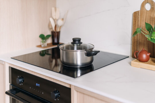 Modern kitchen with black induction hob and built-in oven