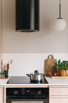 Modern minimalist kitchen with induction hob, oven, and extractor hood