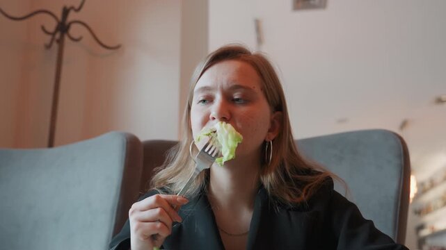 Caucasian woman reacting to bitter salad, sudden grimace and cough in modern cafe closeup dining shot showing expressive facial reaction, spit and hand covering mouth, awkward comedic moment