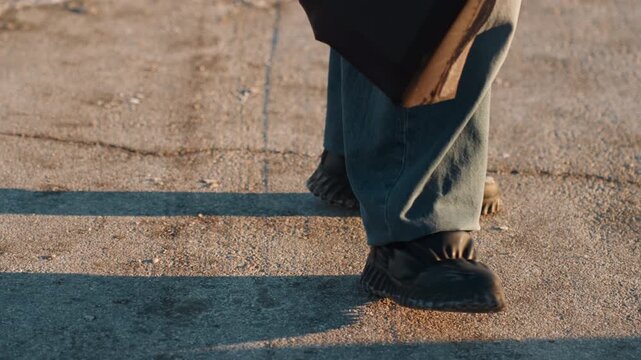 Boots splash through melting snow. Disturbed puddles reflect energetic urban winter hustle and bustle. Closeup of footwear splashing through thawing water during busy city worker commute