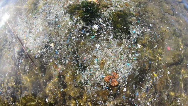 Microplastics, packaging waste, and trash accumulating on the ocean surface. A compelling video addressing the issues of marine pollution, environmental disaster, and ecological crisis.