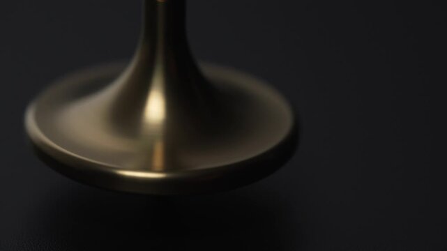 Close-Up Golden Spinning Top Rotation with Copy Space on Black Background