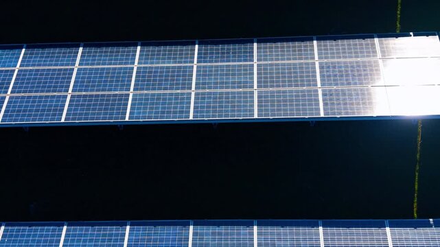 Solar panels on a roof during daytime. Solar panels are arranged in a row on a roof under bright sunlight. They are collecting energy for use.