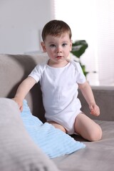 Fototapeta premium Cute little baby boy on sofa at home