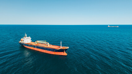 Cargo ship anchored in calm Mediterranean Sea under clear blue sky aerial drone view near Catalonia coast Spain © StockMediaSeller