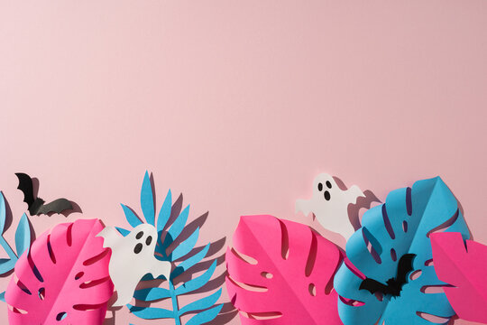 Tropical Halloween paper craft with pastel monstera leaf, ghost cutouts and bats on pink background