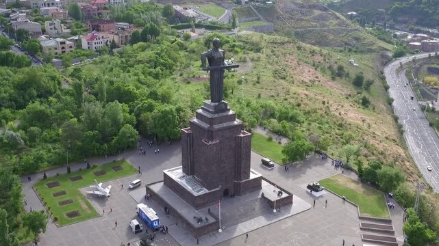 Aerial view of the Mother Armenia monument in Yerevan, featuring a military ceremony at the base of this giant statue on a bright sunny day in late spring.

