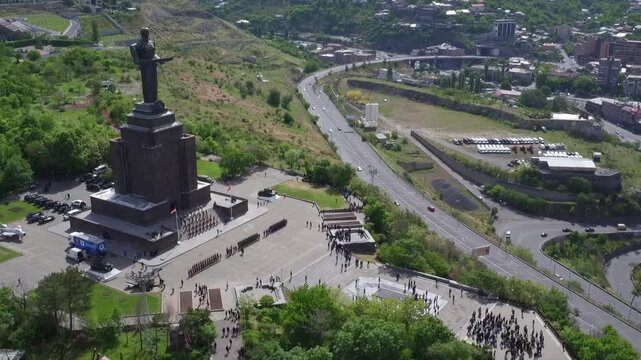 Aerial view of the Mother Armenia monument in Yerevan, featuring a military ceremony at the base of this giant statue on a bright sunny day in late spring.

