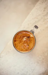 Coffee cup from above, Espresso foam texture, creamy coffee, rich, freshly brewed cup of hot latte. Top view of cappuccino milk foam closeup. Creamy coffee macro shot, on a marble table, top view © Subbotina Anna