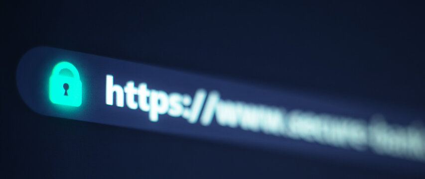 Close up of a web browser address bar displaying a glowing green padlock and secure https URL on a computer screen