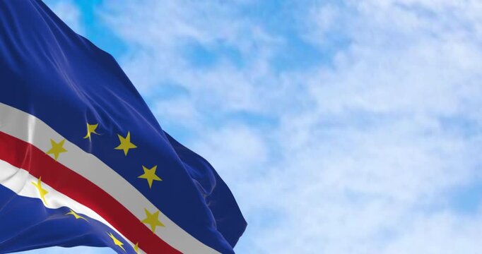 Cape Verde national flag waving on a clear day. Blue, white, and red bands with ten yellow stars representing the main islands. Seamless 3d render animation. Slow motion loop. Selective focus