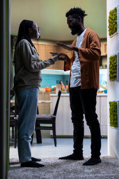 Black couple, heated argument indoors, aggression and unhappiness, Two people reflecting stress and emotional tension leading to angry quarrel, relationship conflict and drama.
