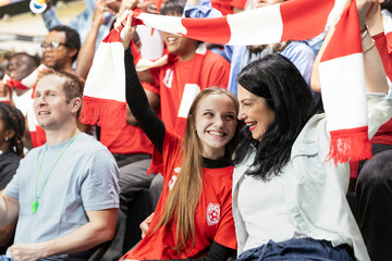 Fototapeta premium Sports crowd cheering during soccer match in stadium stands full of hardcore football fans chanting, women in football Multigenerational inclusive football culture driven by passion.
