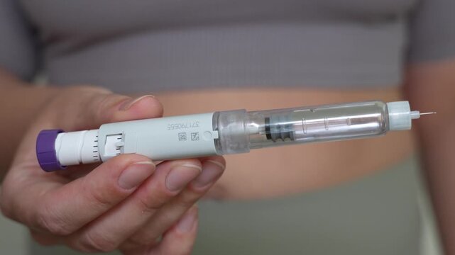 Woman holding GLP-1 injection pen for weight loss treatment close-up