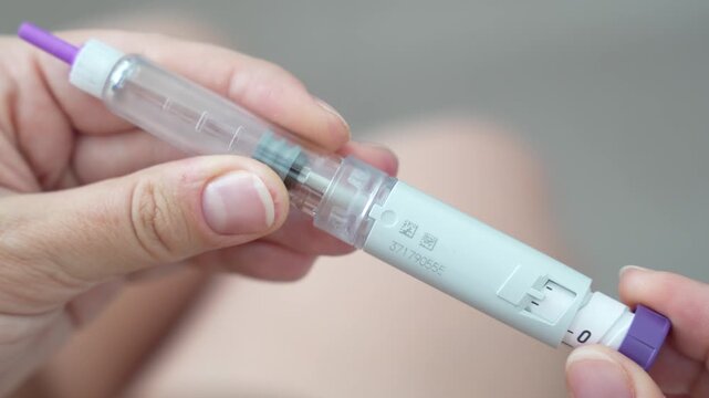 Woman setting dosage clicks on GLP-1 injection pen close-up