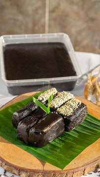Traditional Indonesian Black Glutinous Rice Dodol Cake on Banana Leaf with Sesame Topping (Jenang Ketan Hitam)