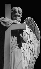 Obraz premium Mourning angel resting on a cross, symbolizing grief, remembrance and eternal hope.